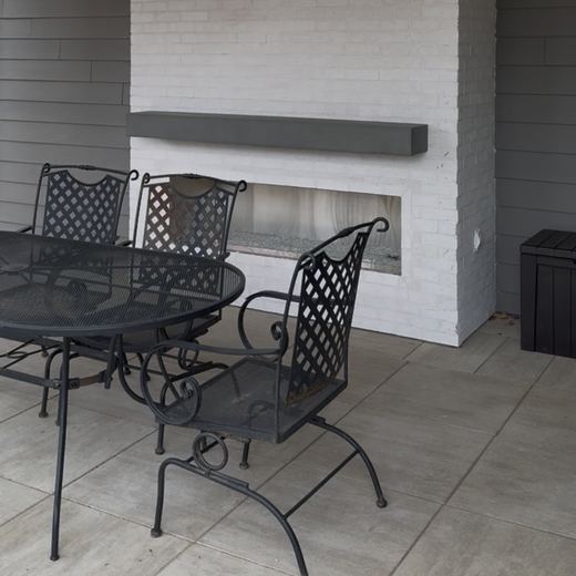Covered patio with a white brick fireplace and mantel, in progress, RDH Construction