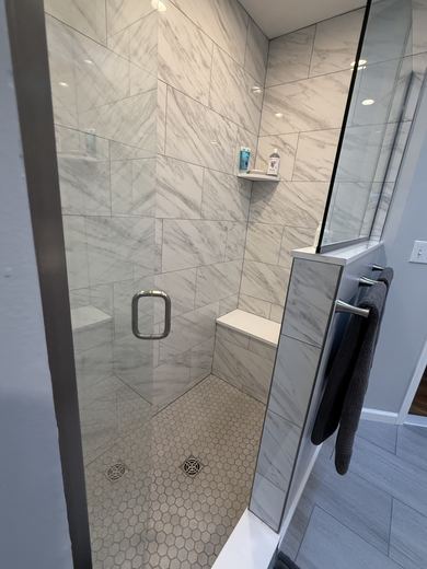 Tiled walk-in shower with bench, remodel by RDH Construction