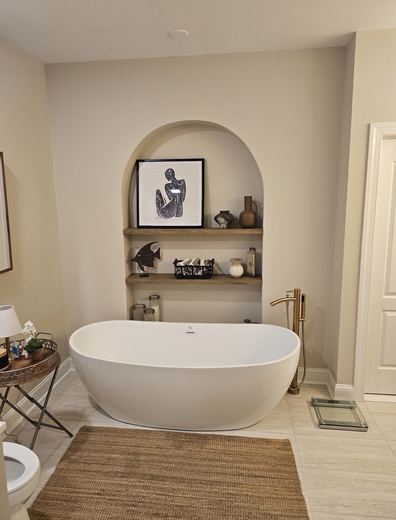 Freestanding tub in front of an arched niche, bathroom remodel by RDH Construction